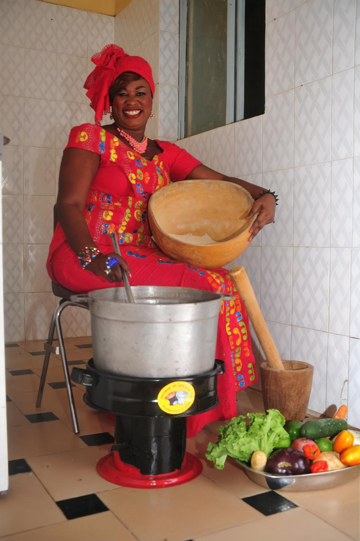 A woman cooks on a climate-friendly cooker.