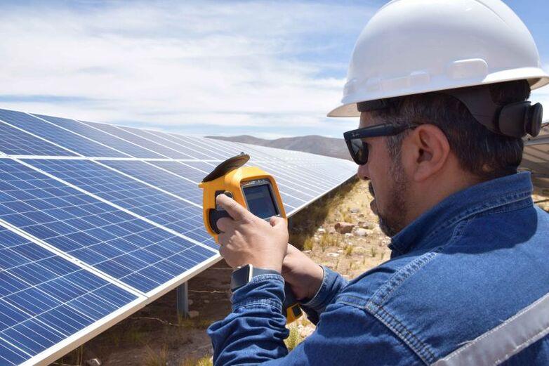 Un técnico mide la potencia de varios paneles solares mediante una cámara termográfica