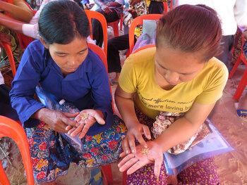 Zwei Frauen vergleichen während einer Schulung Reisqualitäten © GIZ