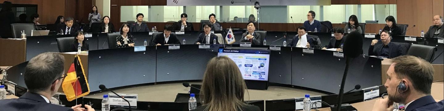 Teilnehmer*innen eines Treffens des deutsch-koreanischen Digitaldialogs sitzen in einem Konferenzraum.