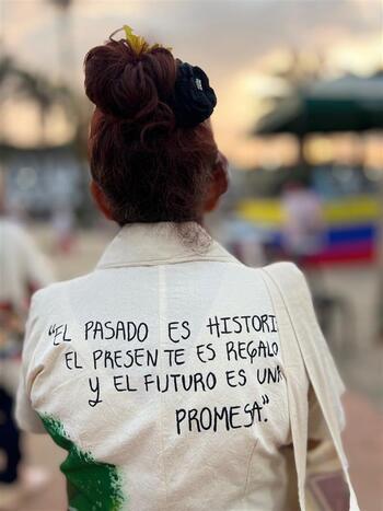 A woman wearing a t-shirt with a text on the back commemorating victims.