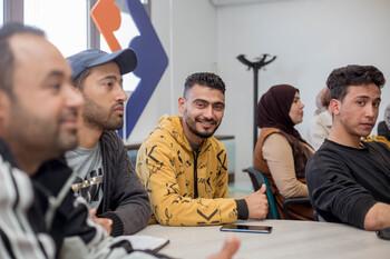 Jugendliche sitzen zusammen bei einer Informationsveranstaltung zu Unternehmertum.