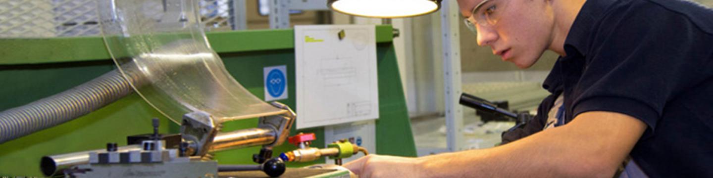 Ein junger Mann arbeitet in einer Werkstatt.