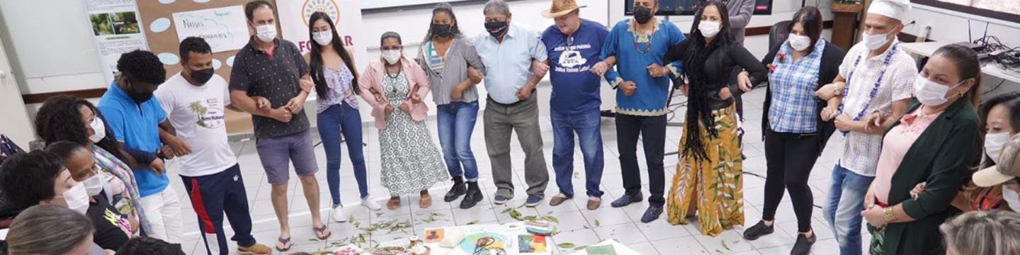 As pessoas ficam em um círculo, de braços dados.