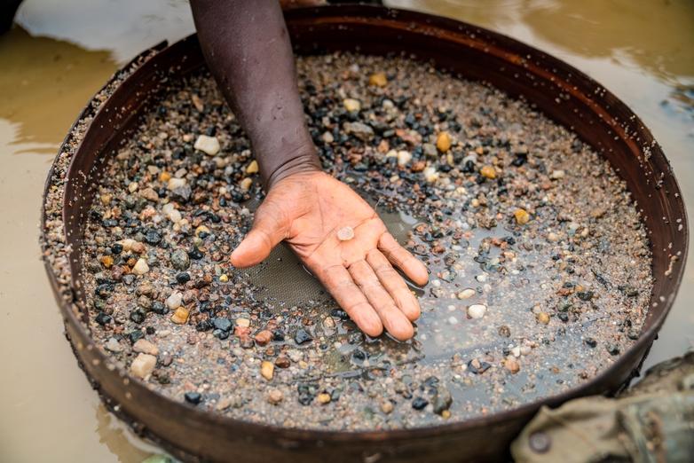 Une main montre un diamant trouvé à l’aide d’un tamis. Copyright : GIZ / Michael Duff