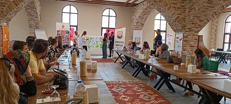 People at a workshop sit and listen to a presentation.
