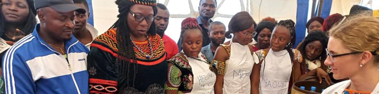 Des personnes sont rassemblées autour d'une table où sont exposés des champignons cultivés.