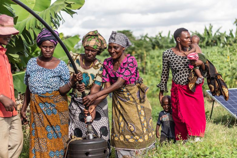A group of women interacting with a solar powered irrigation system.