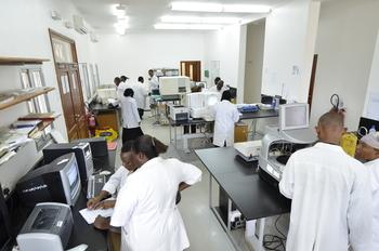 Healthcare workers stand in front of technical devices.