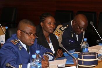 Three police representatives sit at conference tables at an event.