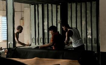 Three men working on animal hides in a tannery. © GIZ/Victoria Hohenhausen