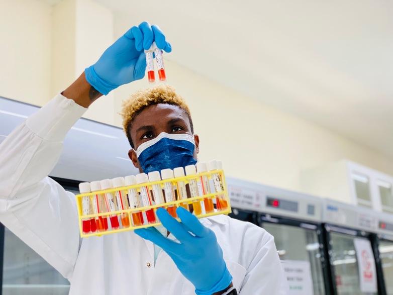 A man wearing a lab coat examines two samples in test tubes. © GIZ/Nadia Said