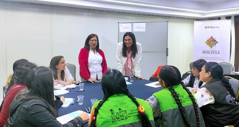 Mehrere Personen sitzen an einem großen Tisch und sprechen miteinander.