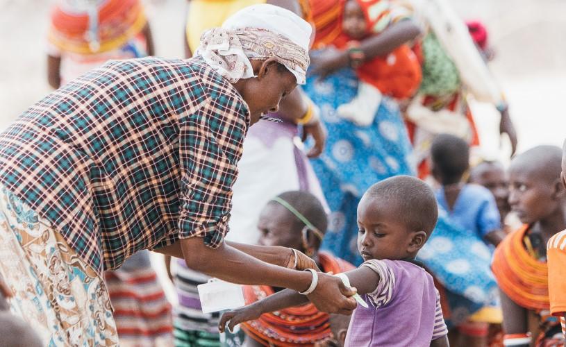 A ribbon is placed around the upper arm of a small child.