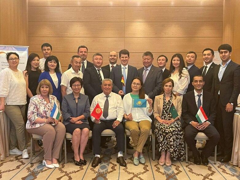 Eine Menschengruppe vor einer vertäfelten Wand.