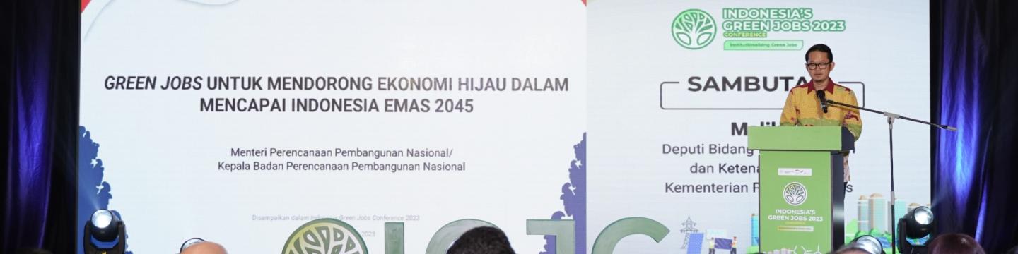 Bappenas-Vizeminister Maliki steht an einem Pult auf einer Bühne und eröffnet die Green Jobs Conference im Dezember 2023.