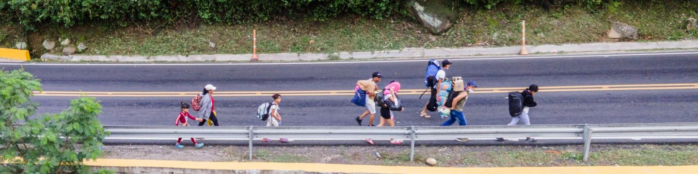 Menschen auf der Flucht laufen auf einer Straße.