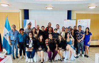 People standing and sitting together for a photo at an event.