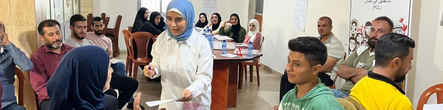 Flüchtlinge und aufnehmende Bürger*innen sitzen bei einer Arbeitsgruppe in einem Raum zusammen.