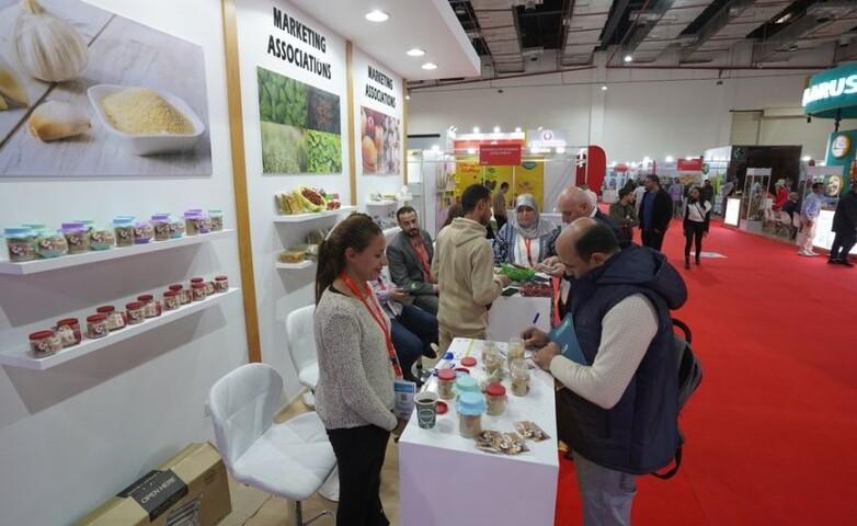 People at a stand at an agricultural fair.
