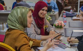 Three finalists of the Green Startup competition chat to each other at a training session on entrepreneurship.