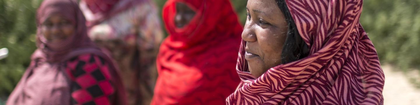 Hände markieren eine Stelle auf einer Landkarte.