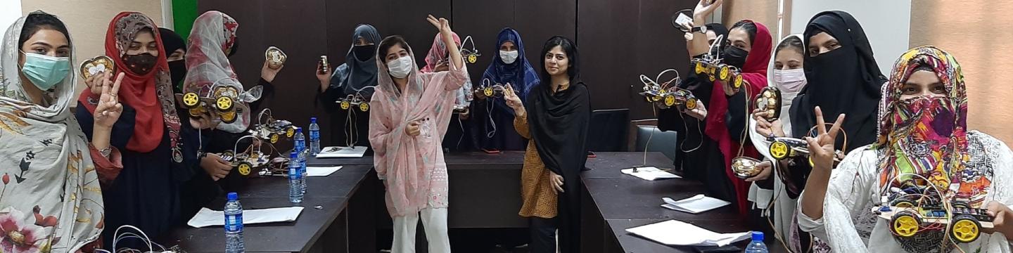 Junge Frauen bauen ferngesteuerte Modellautos in einem technischen Workshop. Copyright: GIZ