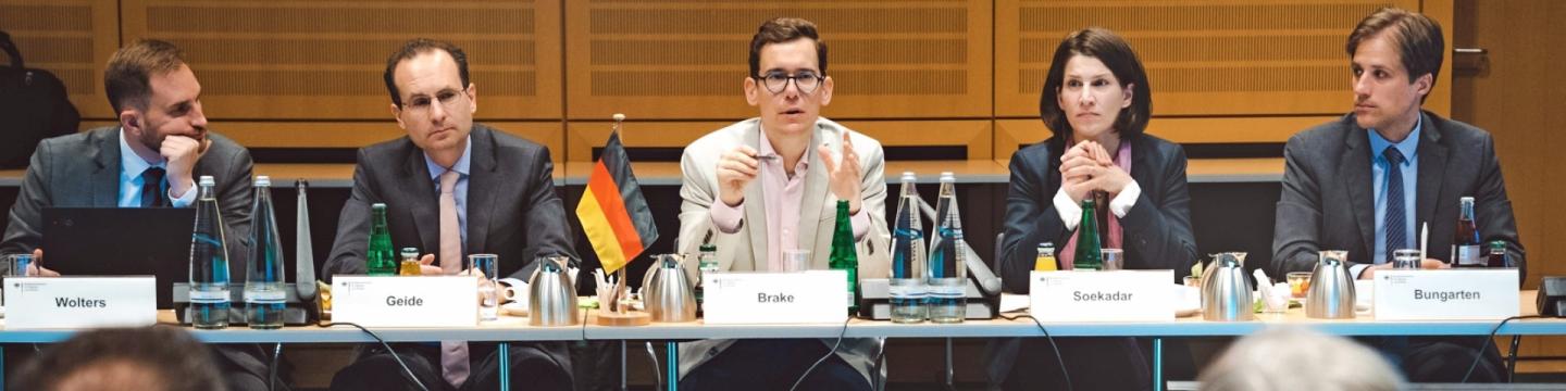 Brasilianische and deutsche Vertreter*innen sitzen an Tischen und tauschen sich im Digitaldialog aus.