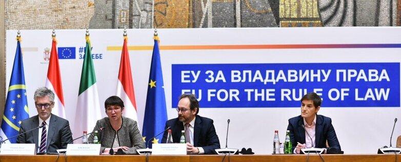 Politische Vertreter*innen sitzen bei einer Veranstaltung auf einer Bühne.