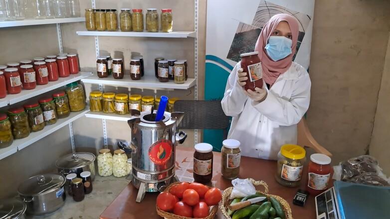 A woman wearing a mask holds a glass in her hand.