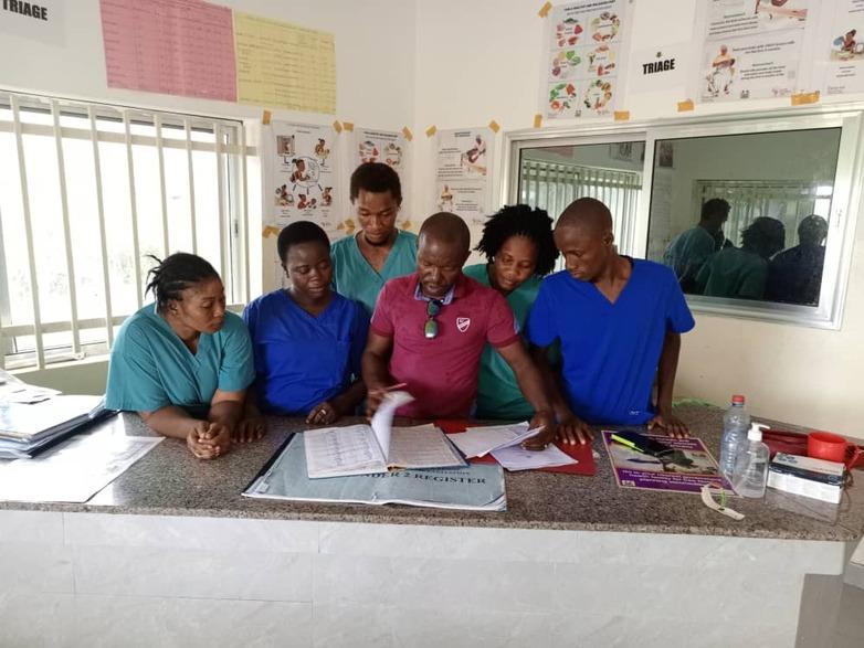 Gesundheitspersonal sitzt zusammen und prüft Dokumente.