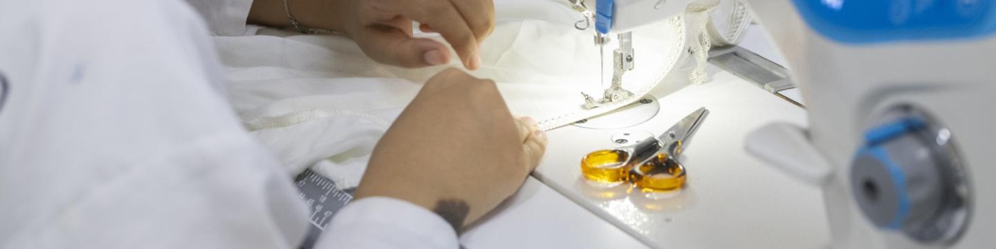 Eine Frau arbeitet an einer Nähmaschine.