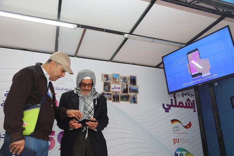 Two men look at a smartphone.