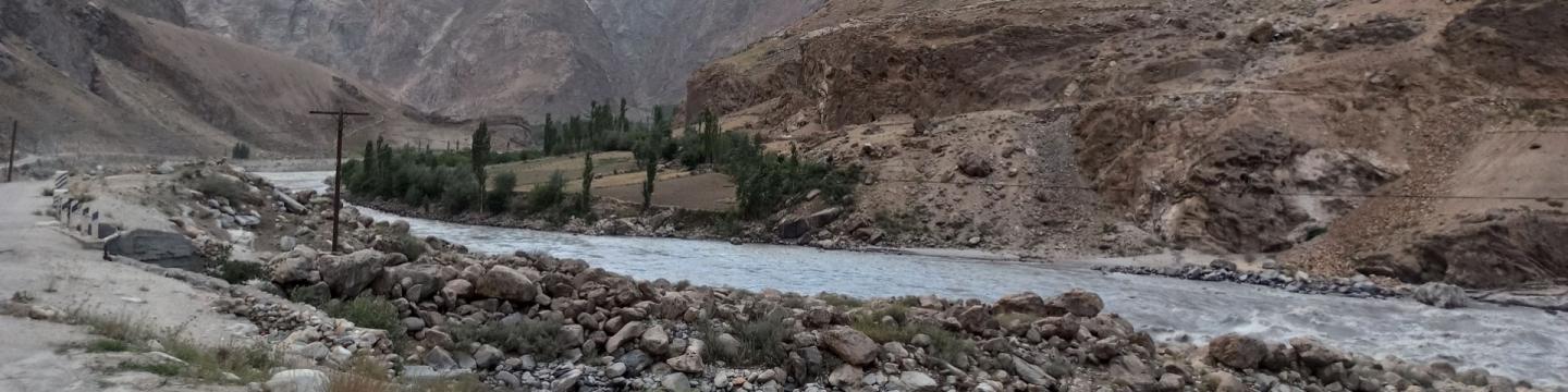 Ein Fluss fließt durch eine steinige, gebirgige Landschaft