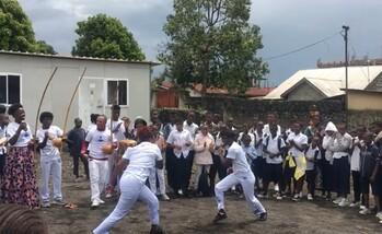 Zwei Personen kämpfen in Nord-Kivu Capoeira. Ein Kreis von Menschen um sie herum feuert die Kämpfer an.