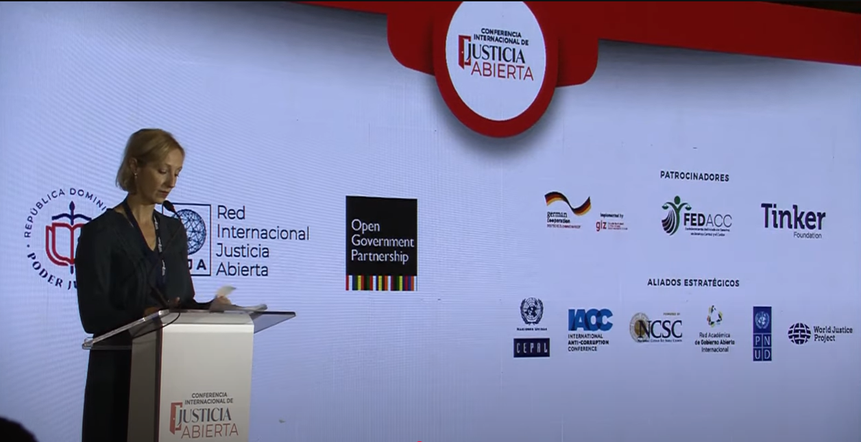 Eine Frau spricht bei der internationalen Konferenz für offene Justiz auf der Bühne.