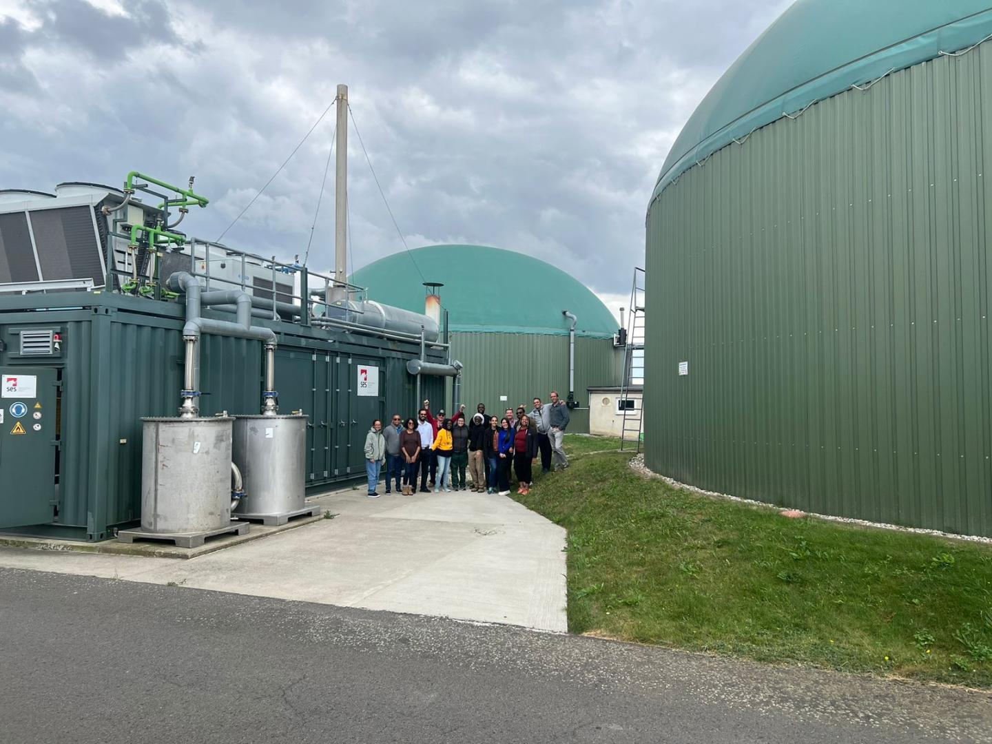 A group is standing by a biogas plant.