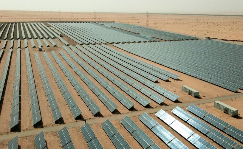 Rows of solar panels installed in a desert landscape in Tunisia.