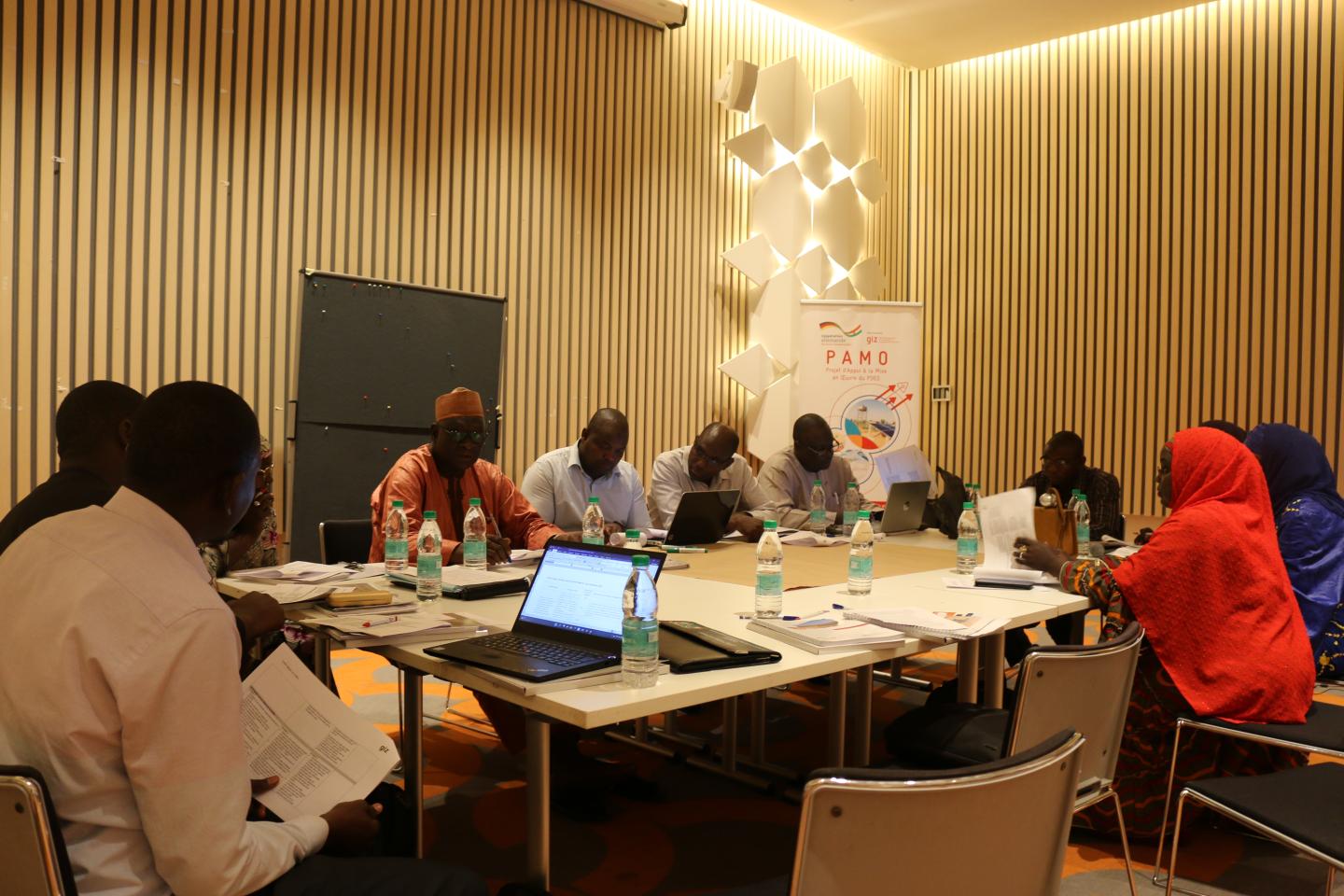 Des Nigériennes et Nigériens échangent autour d’une table.