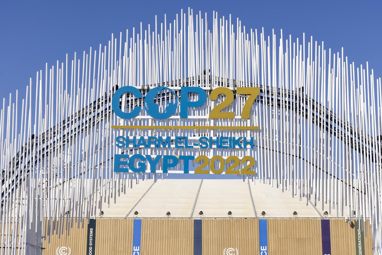 Entrance gate to the climate conference in Sharm El-Sheikh. The conference logo is prominently displayed in the centre of the image.