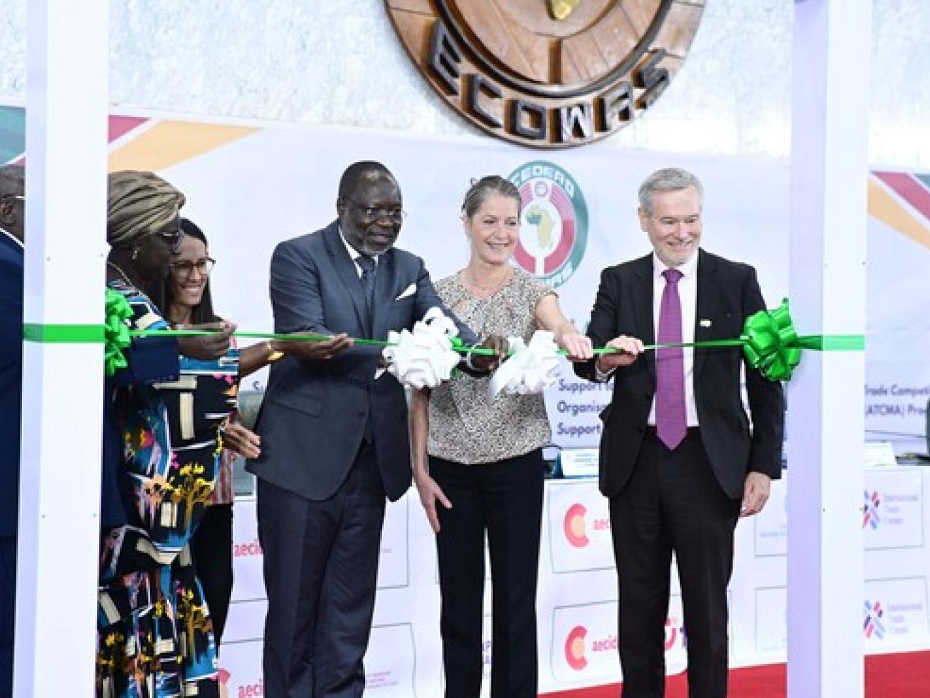 Personen schneiden gemeinsam ein grünes Band durch