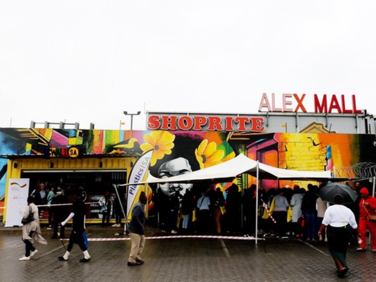 People walking and waiting in line in front of "ALEX MALL"