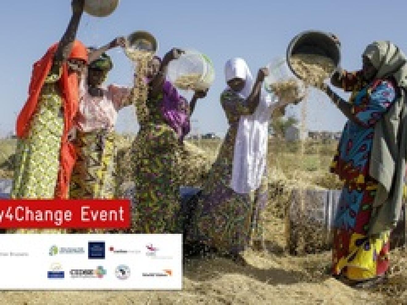 Frauen stehen in einem Feld und schütten den Inhalt ihres Eimer aus