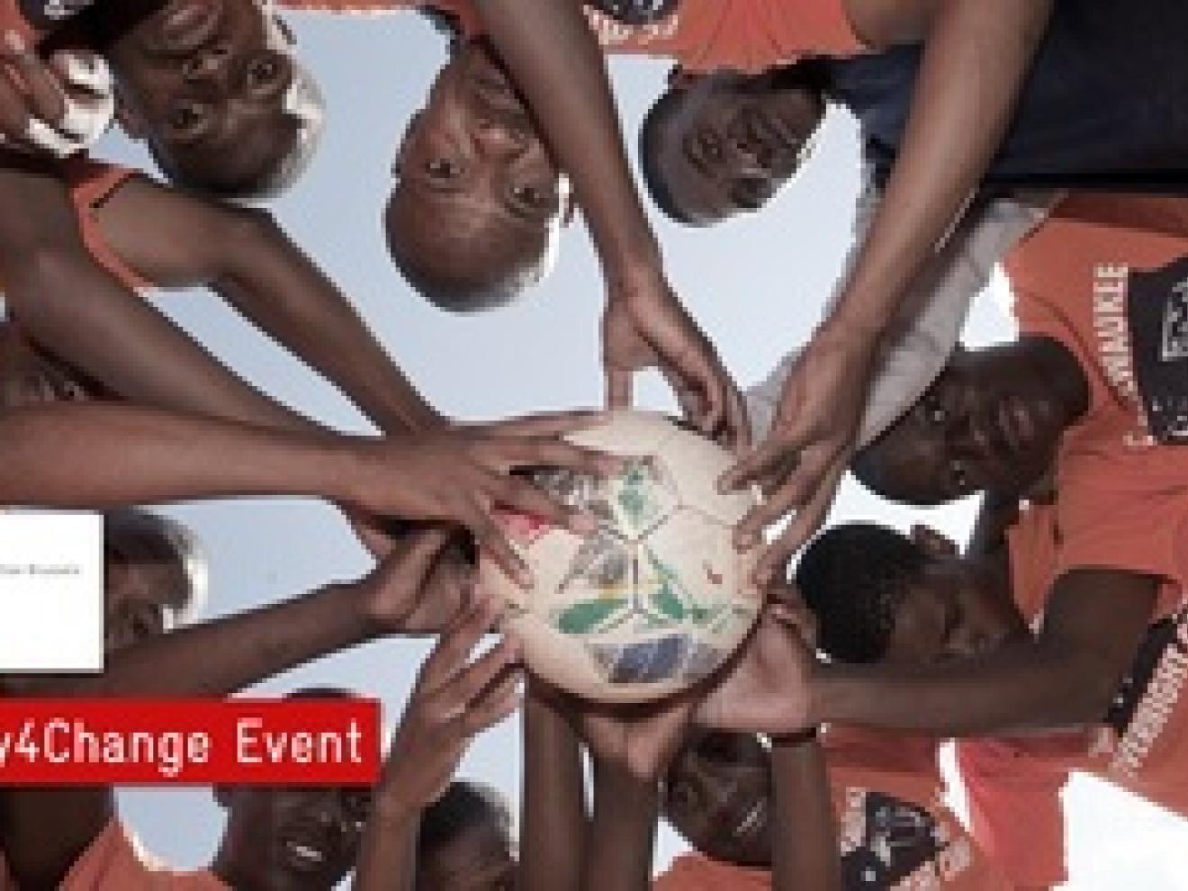 Viele Jungs halten einen Fußball zusammen in der Mitte