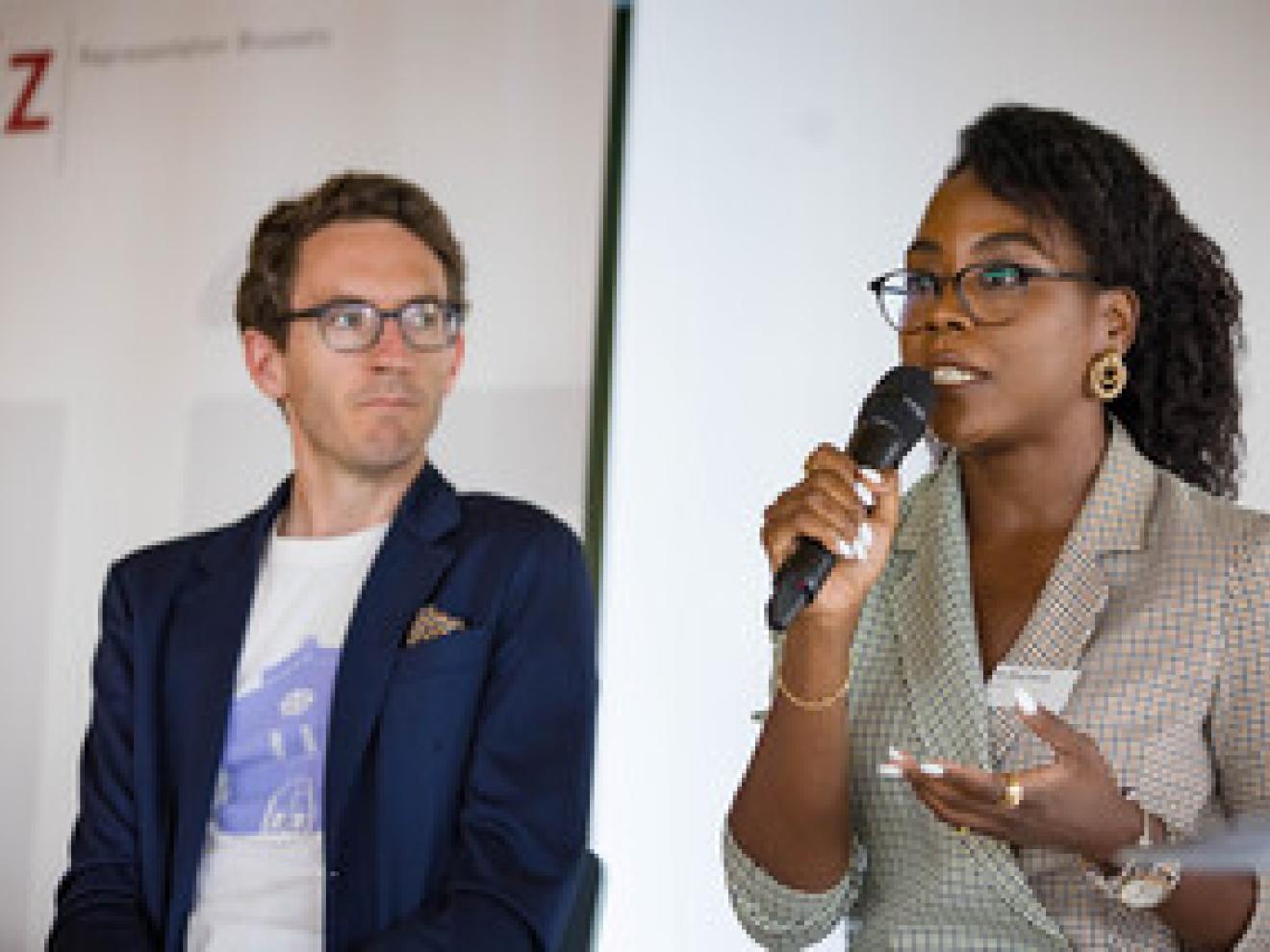 Eine Frau hält ein Mikrofon in der Hand. Neben ihr steht ein Mann