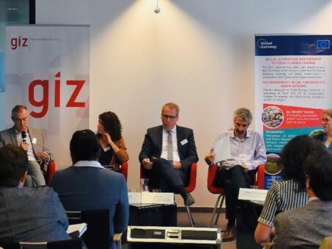 Personen sitzen vor einem Publikum