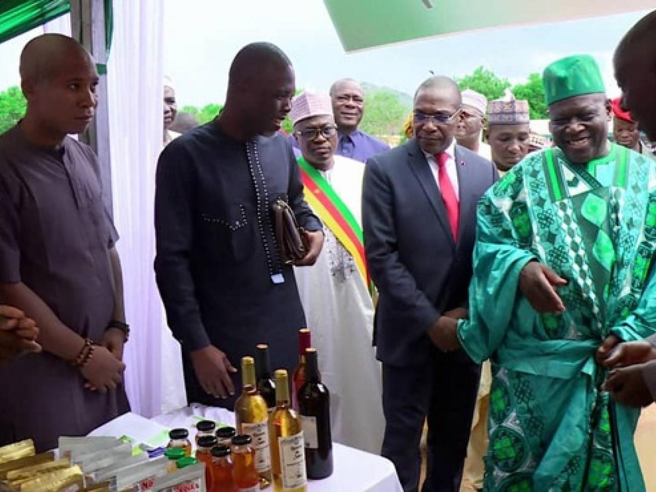 Viele Personen stehen um einen Tisch herum auf dem Flaschen stehen