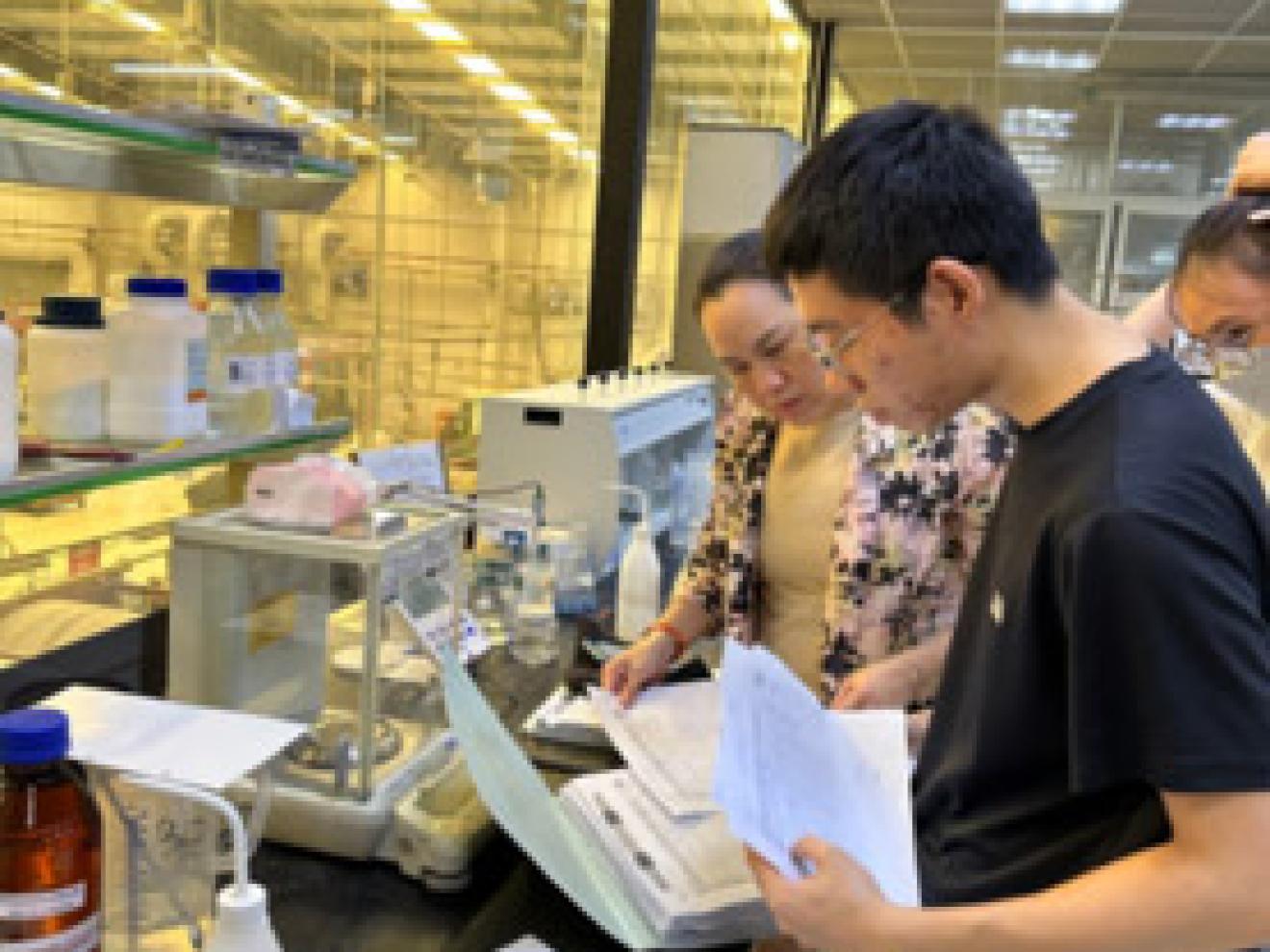 Group of people checking papers in a factory