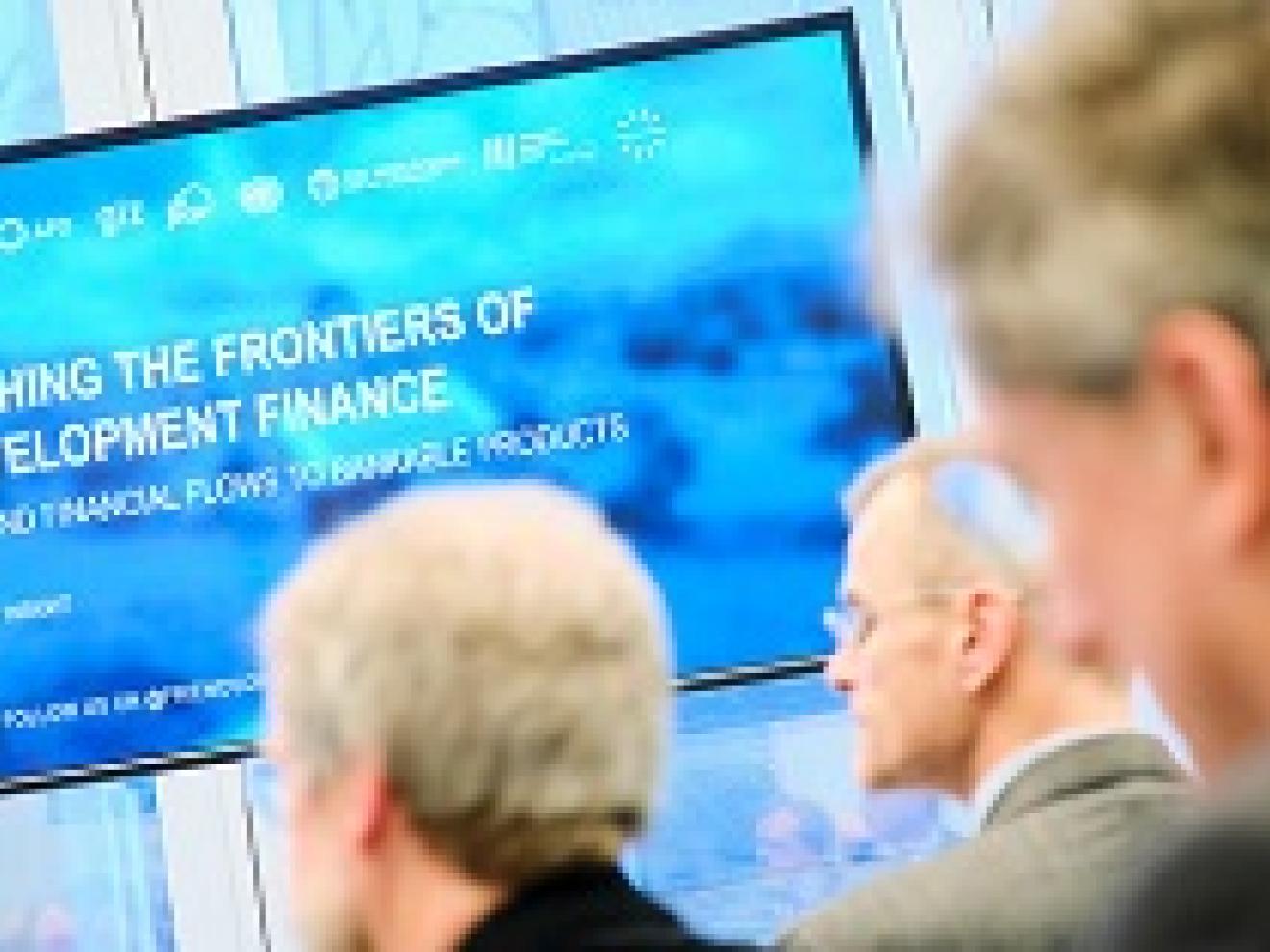 Bildschirm mit der Aufschrift "Pushing the frontiers of development Finance"