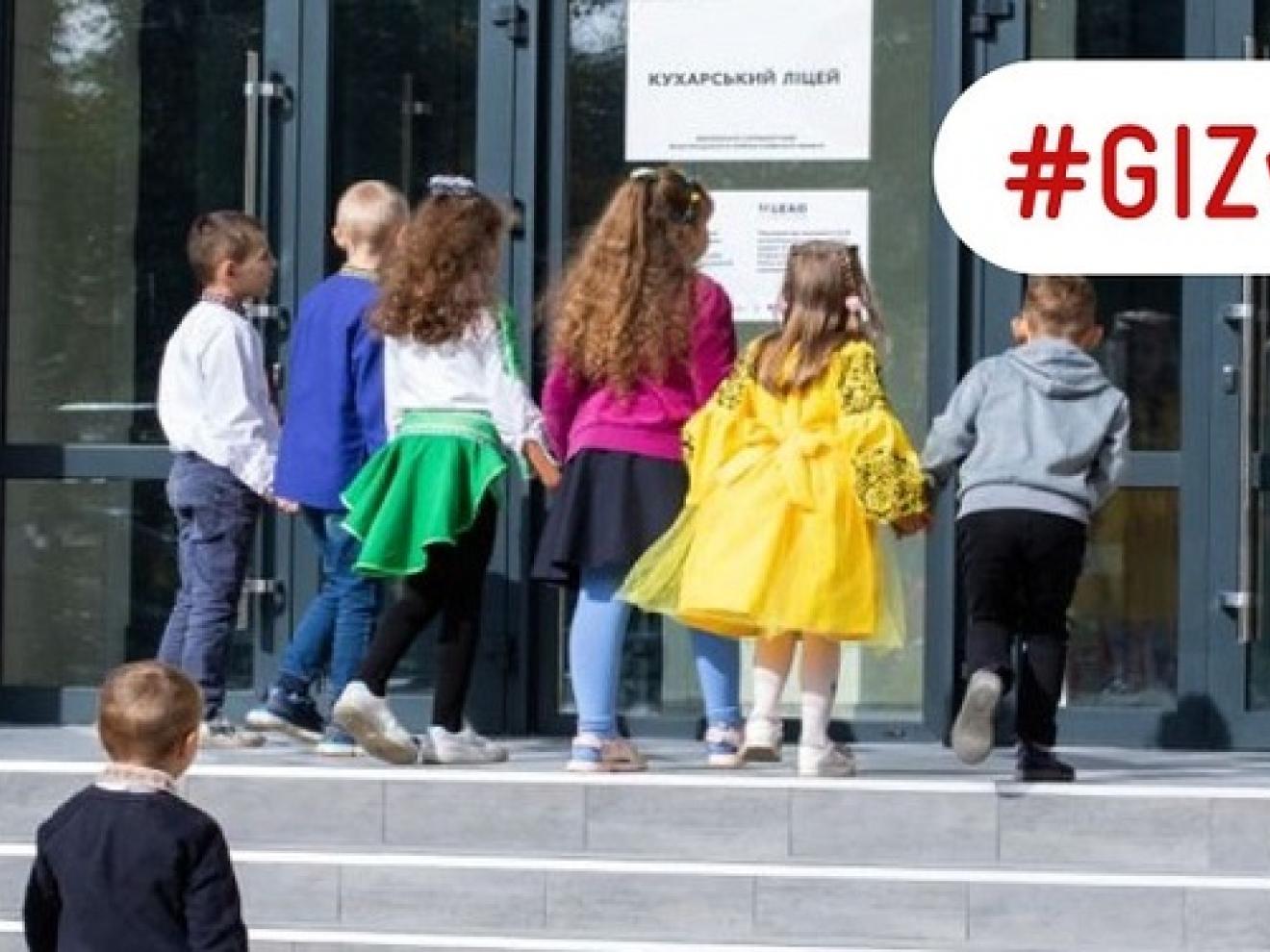 Kinder betreten eine wiederaufgebaute Schule in der Ukraine.